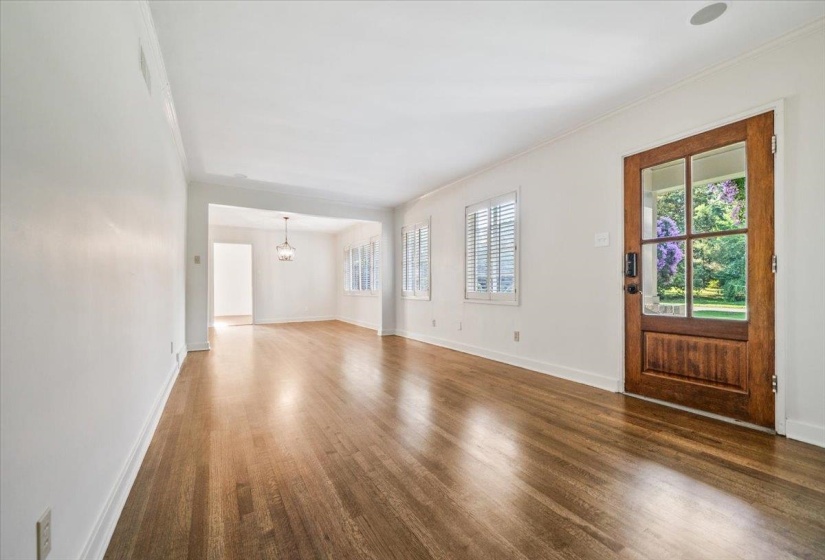 Spacious room with wood-finish flooring, white walls, and bright white trim