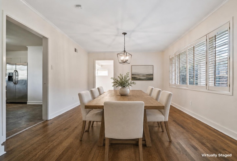 Dining space featuring wood-finish flooring, white plantation shutters, and a contemporary geometric chandelier