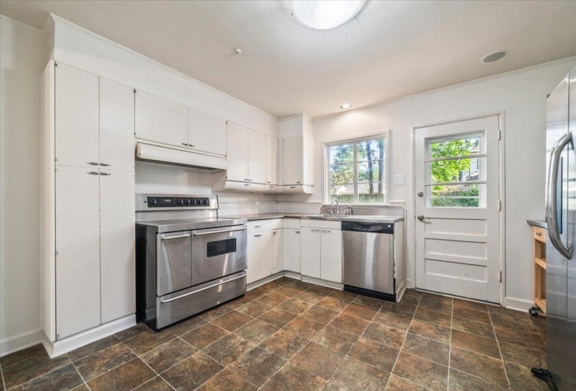 Kitchen featuring white cabinetry, stainless steel appliances, and a tiled floor