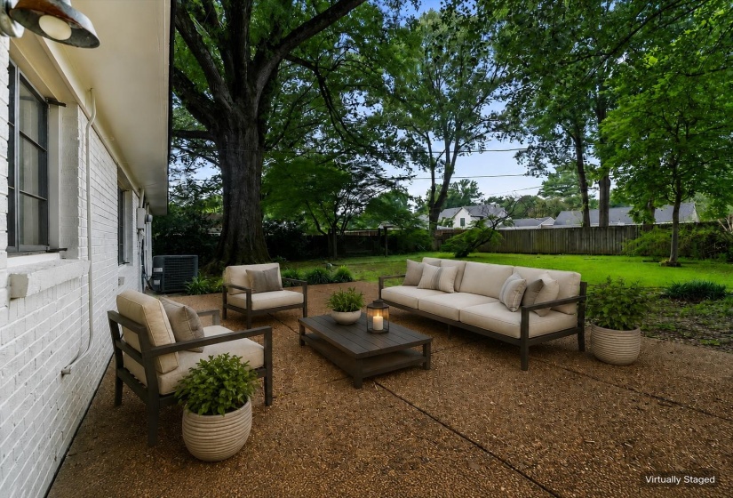 Expansive patio area featuring a textured aggregate surface, providing ample space for outdoor living