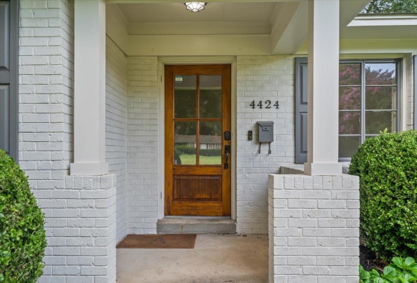 Inviting brick facade with painted white finish and contrasting dark shutters