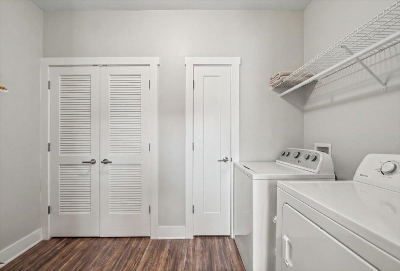 Dedicated laundry area featuring wood-finish flooring and light gray walls