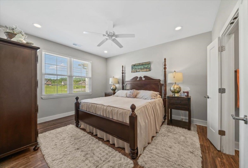 Spacious bedroom featuring wood-finish flooring, recessed lighting, and a ceiling fan