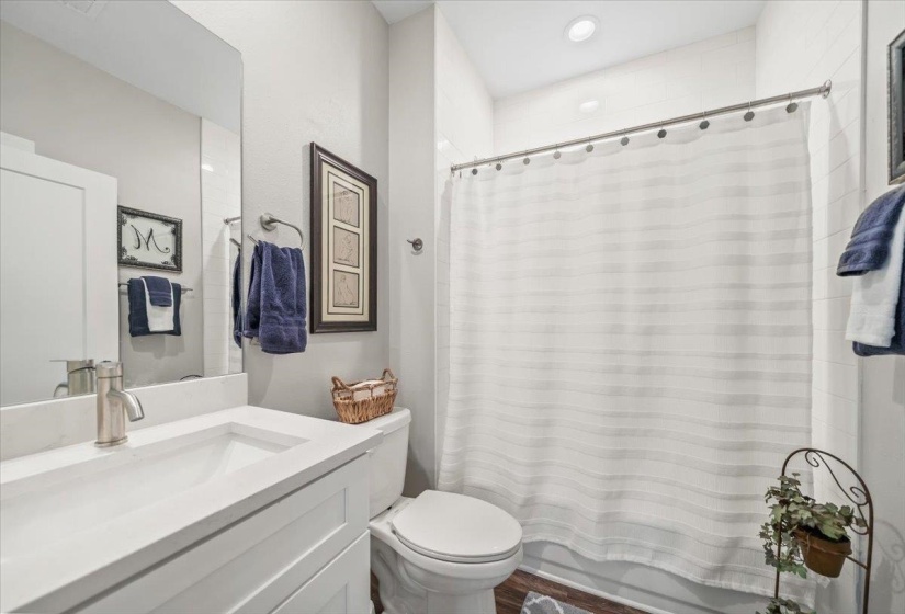 Bathroom featuring a white vanity with an integrated sink, brushed nickel faucet, and a large wall mirror
