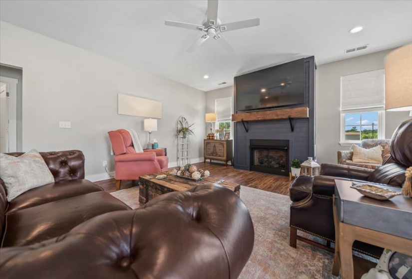 Living area featuring a fireplace with a dark paneled surround and a substantial wood mantle