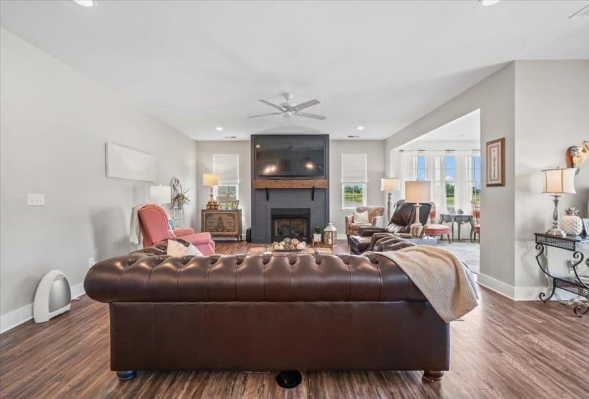 Spacious living area featuring wood-finish flooring, recessed lighting, and a ceiling fan