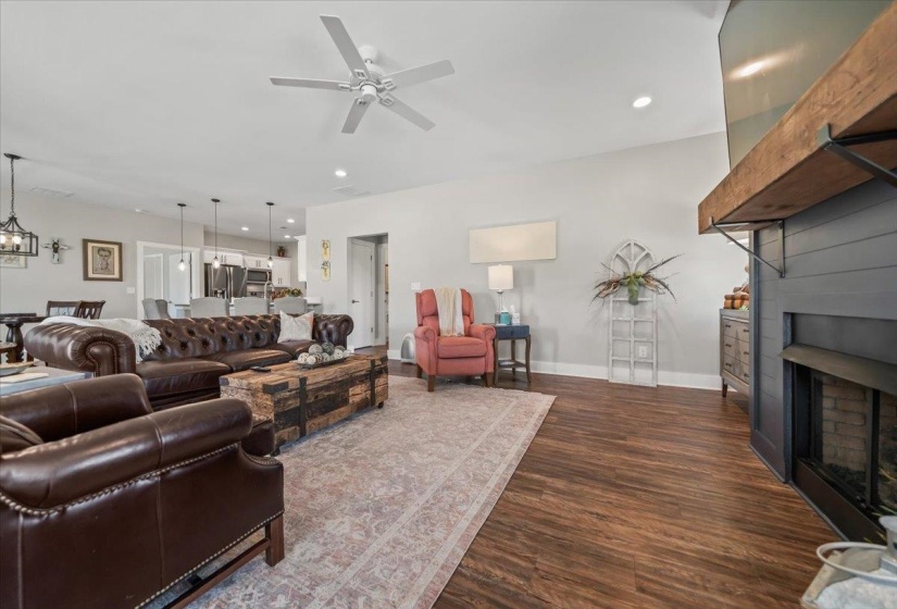 Living area featuring wood-finish flooring, a ceiling fan with integrated lighting, and recessed ceiling lights
