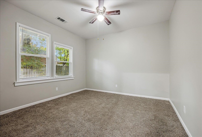 Carpeted spare room featuring baseboards and ceiling fan