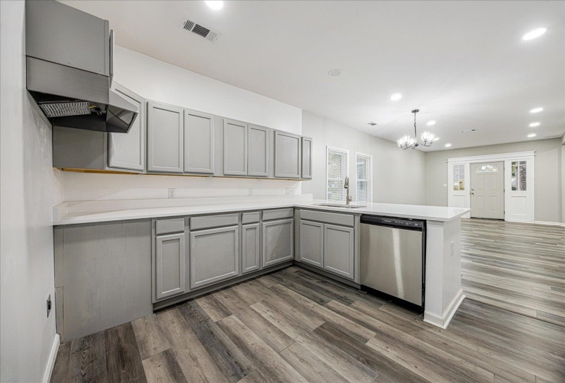 Kitchen featuring gray cabinets, recessed lighting, stainless steel dishwasher, decorative light fixtures, and dark wood-style floors