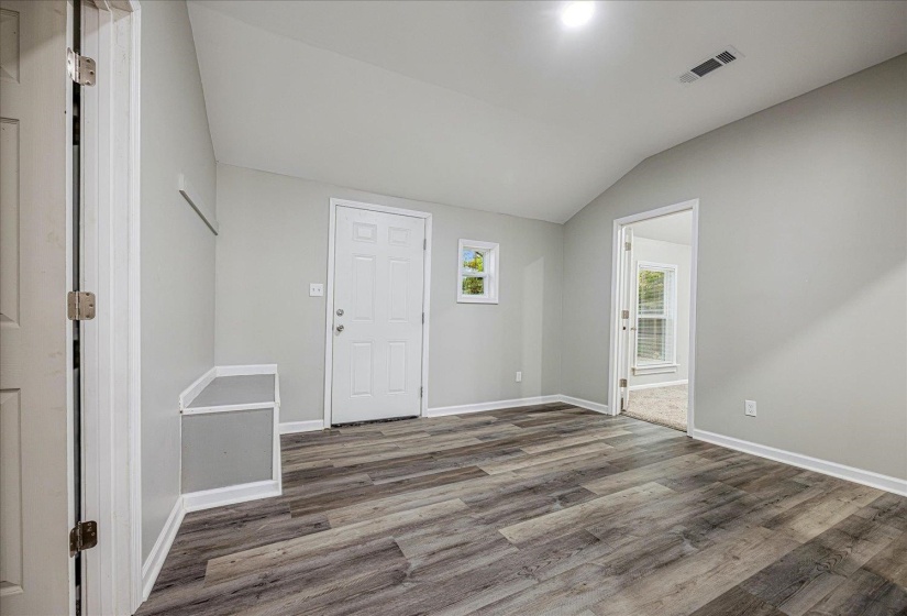 Entrance foyer featuring lofted ceiling and wood finished floors