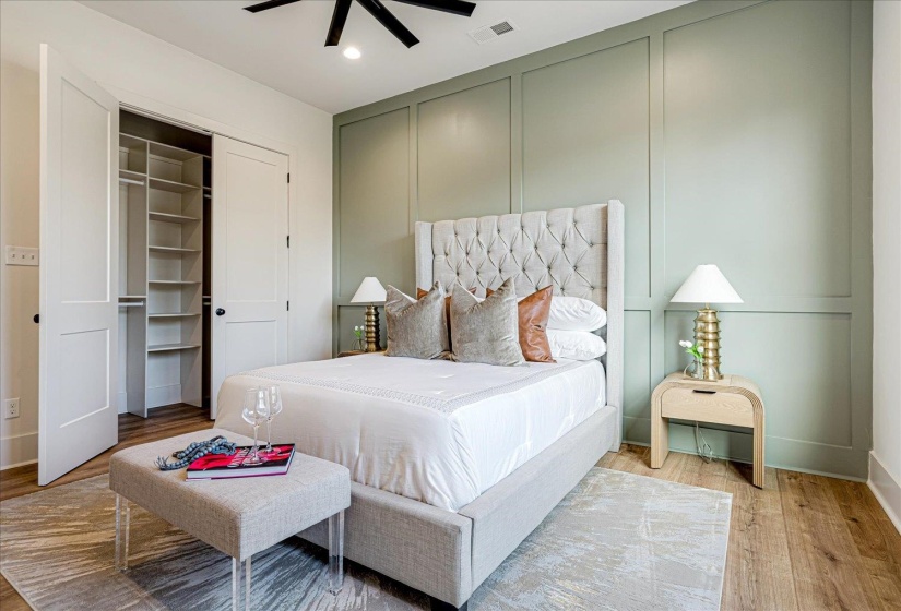 Bedroom with a decorative wall, light wood-type flooring, a ceiling fan, recessed lighting, and a closet