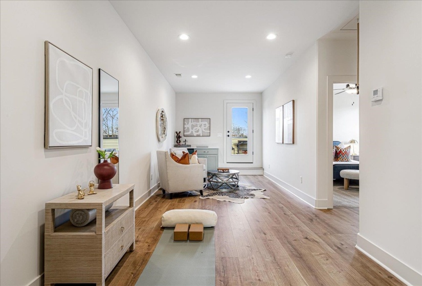 Hall with light wood-style flooring and recessed lighting