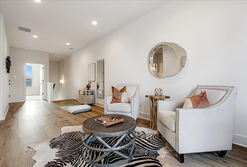 Living area with light wood-type flooring and recessed lighting