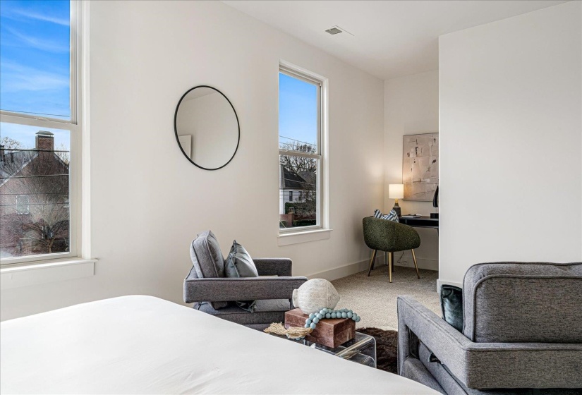 Carpeted bedroom with an office area and baseboards