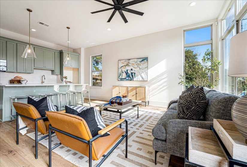 Living room with a ceiling fan, light wood-style floors, and recessed lighting