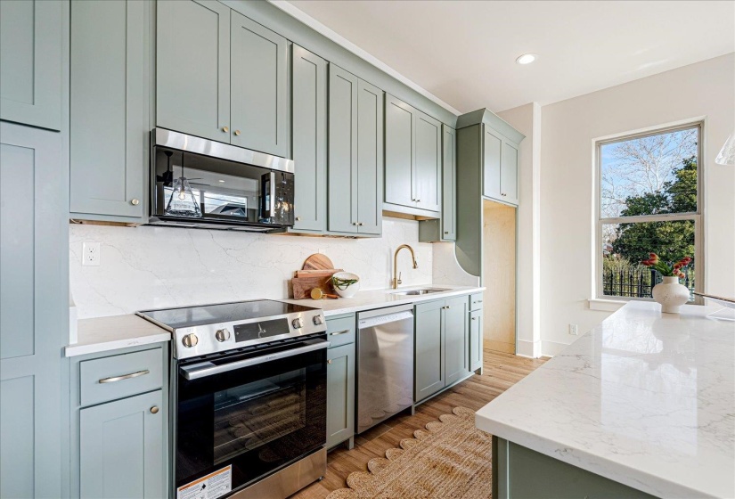 Kitchen with stainless steel appliances, light stone countertops, light wood-style floors, tasteful backsplash, and recessed lighting
