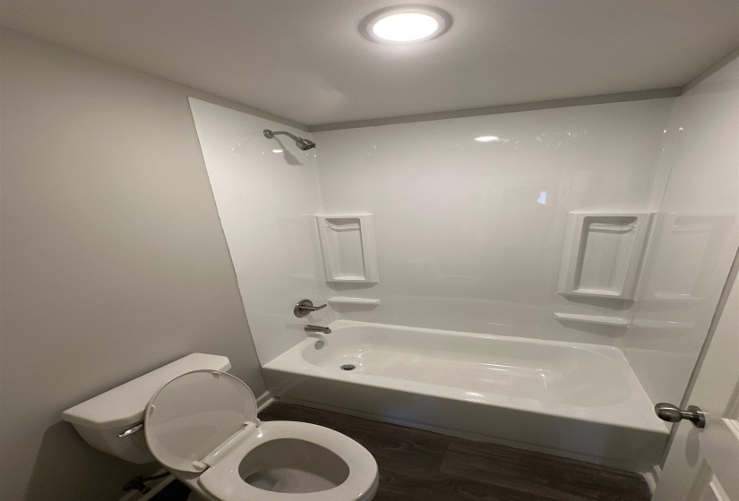 Bathroom featuring shower / bathtub combination and dark wood-style floors