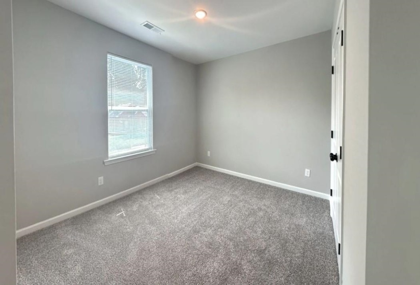 Spare room with light carpet and baseboards