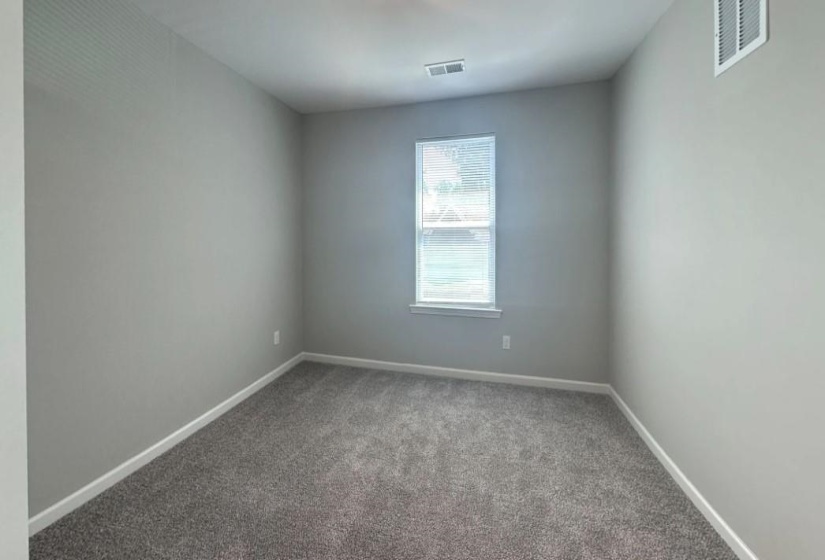 Carpeted spare room featuring baseboards