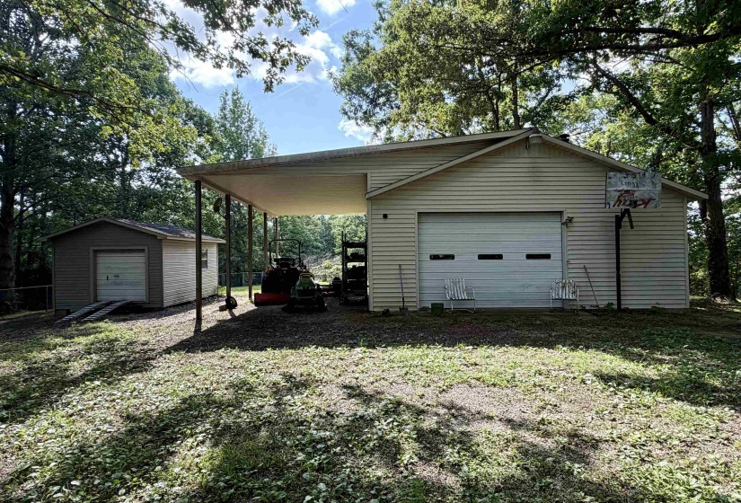 Detached garage featuring horizontal siding and a white paneled garage door