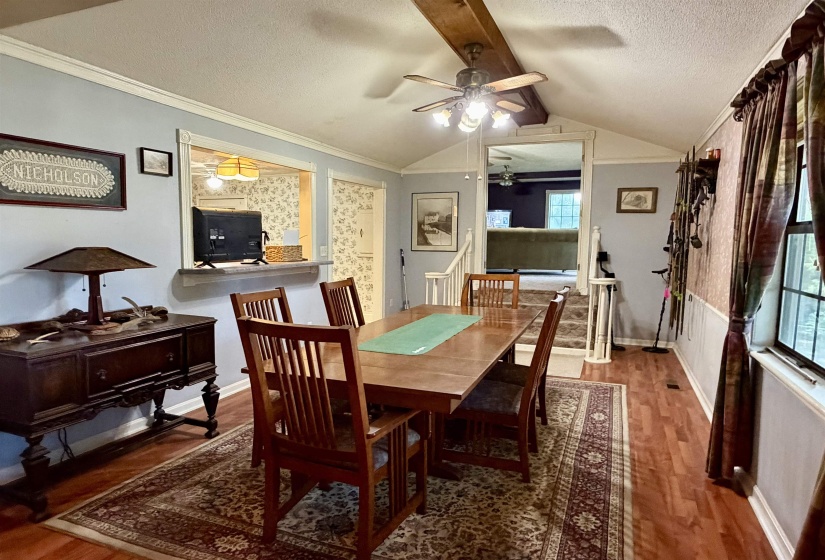 Dining area featuring wood-finish flooring, a vaulted ceiling with exposed beam, and a ceiling fan with integrated lighting