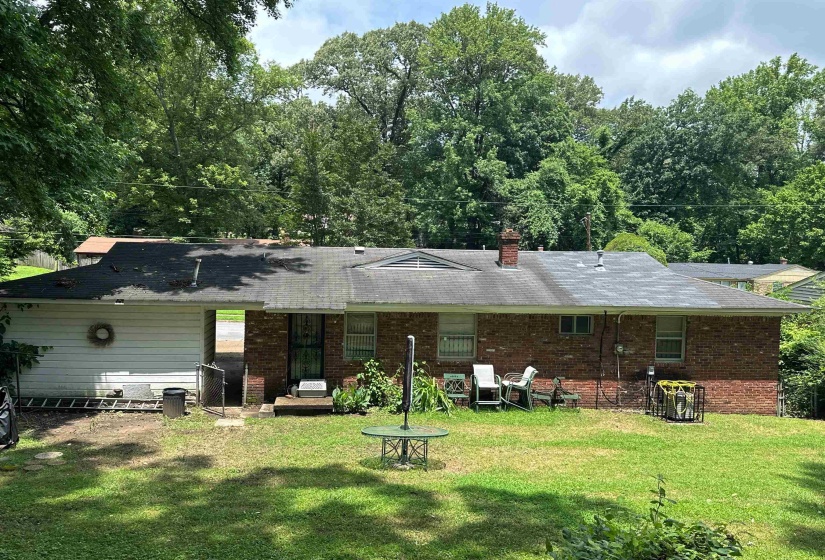Brick and siding exterior with mature trees providing a natural backdrop