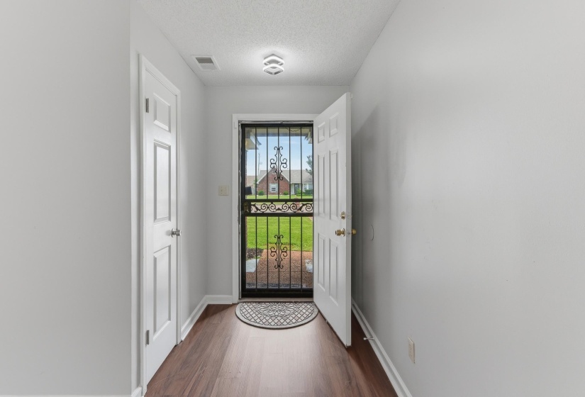 Entryway featuring wood-finish flooring, white trim, and a contemporary ceiling light fixture