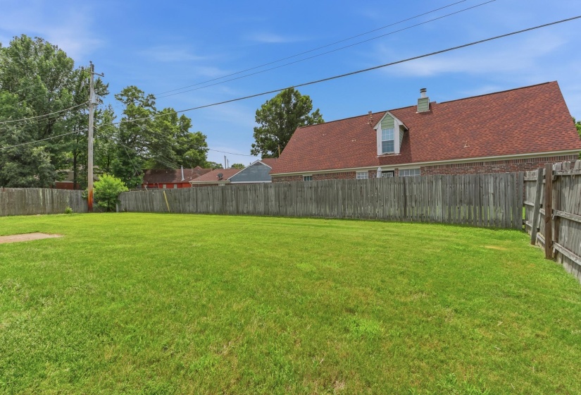 Expansive green lawn surrounded by a wooden privacy fence