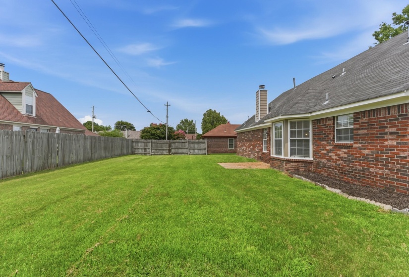 Expansive green lawn surrounded by a wooden privacy fence