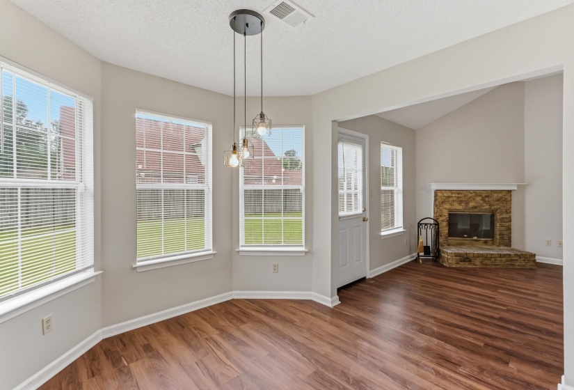 Wood-finish flooring throughout, complemented by a contemporary three-light pendant fixture