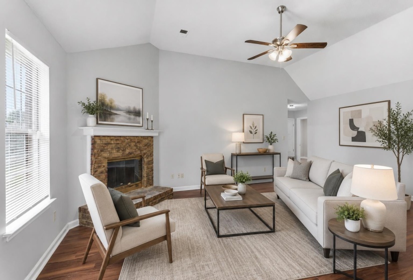 Spacious living area featuring a vaulted ceiling and wood-finish flooring