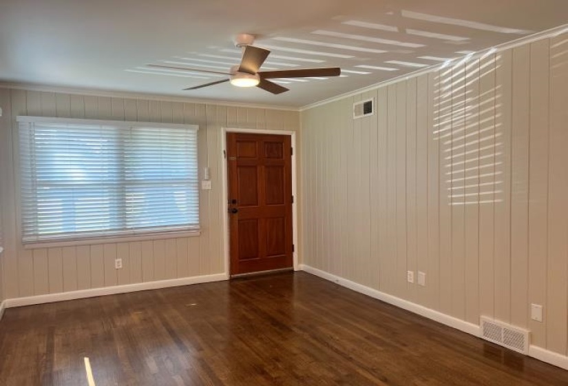 Warm wood-finish flooring complements the light-toned vertical paneling