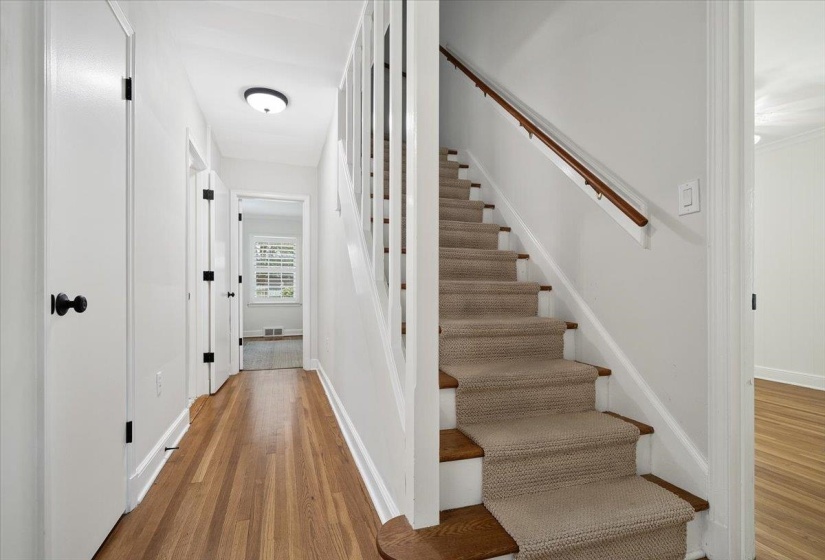 Hallway featuring wood-finish flooring, white walls, and recessed lighting