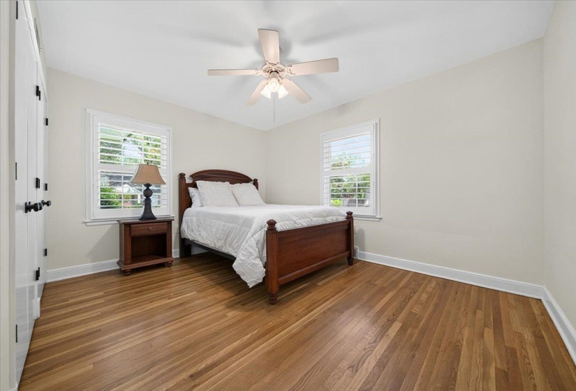 Room featuring wood-finish flooring, white walls, and a ceiling fan with integrated lighting