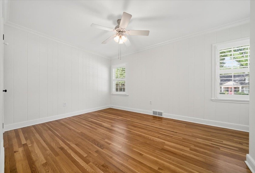 Bright interior space featuring wood-finish flooring, white paneled walls, and white trim