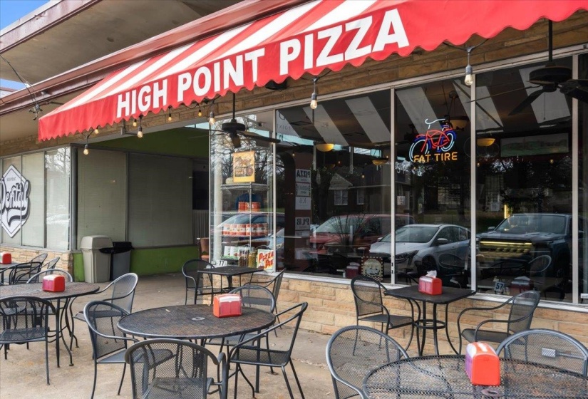 Commercial storefront featuring a red and white striped awning with exterior string lighting