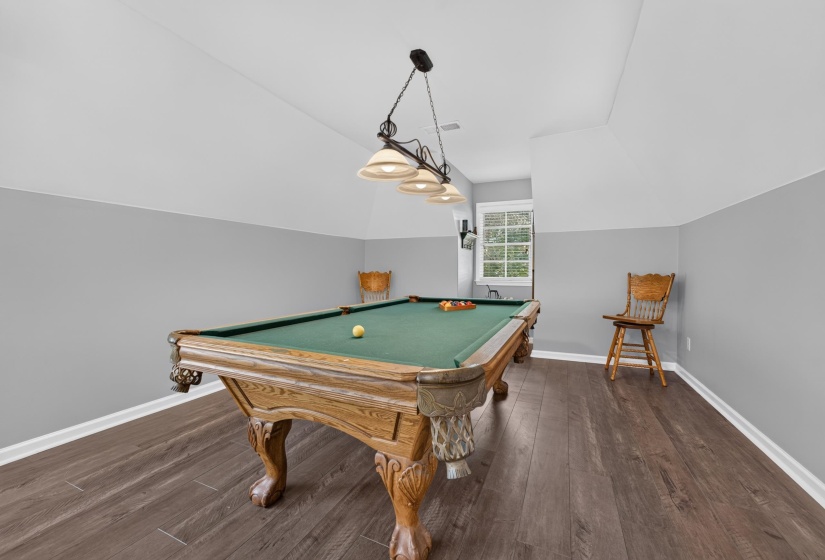 Recreation room featuring wood-finish flooring and a distinctive two-toned wall treatment