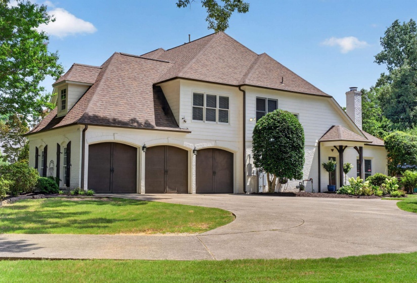 White exterior with a multi-gabled roofline and a three-car garage