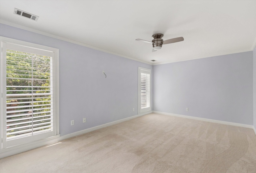 Spacious room featuring neutral carpeting, light-toned walls, and white trim
