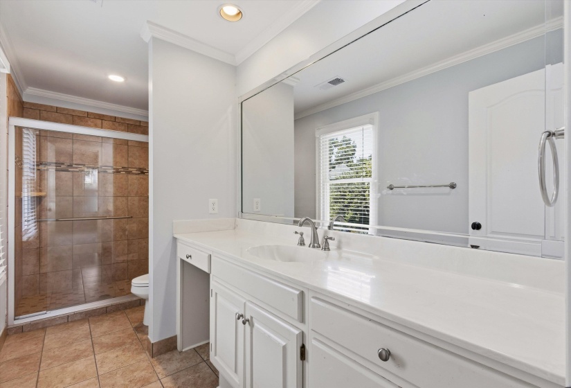 Bathroom featuring a double vanity with white cabinetry, a solid surface countertop, and brushed nickel fixtures