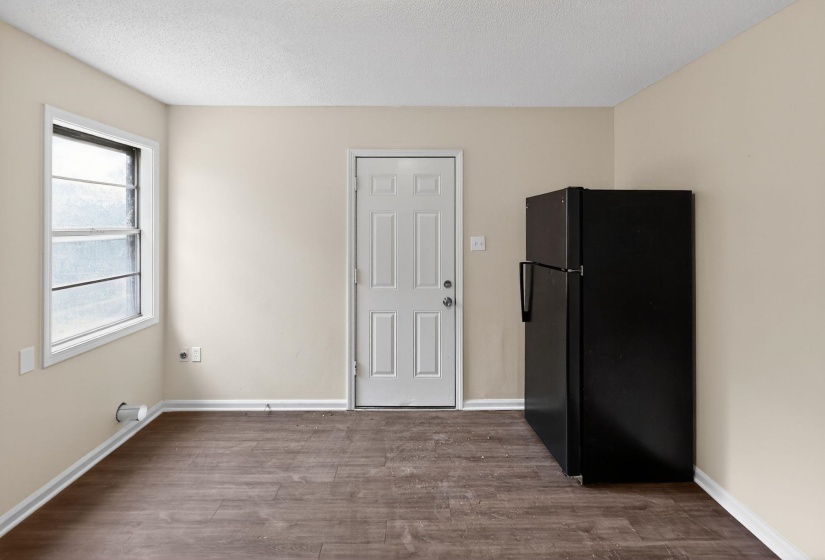 Unfurnished dining area featuring dark wood-style flooring and a textured ceiling