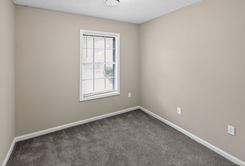 Empty room with carpet flooring and a textured ceiling