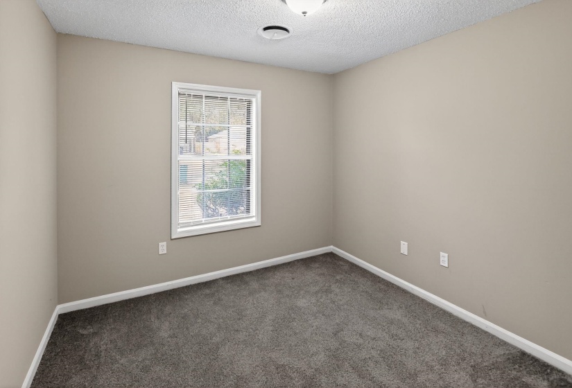 Empty room with carpet flooring and a textured ceiling