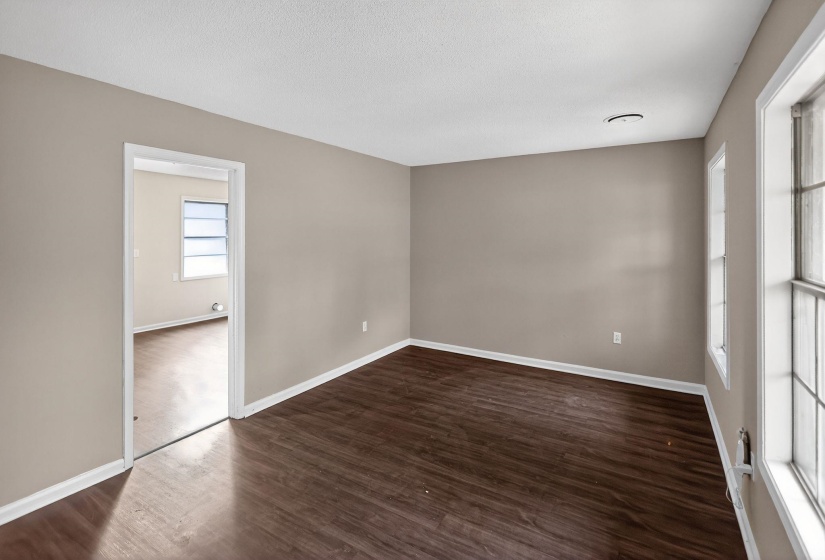 Empty room featuring dark wood-style flooring and a textured ceiling