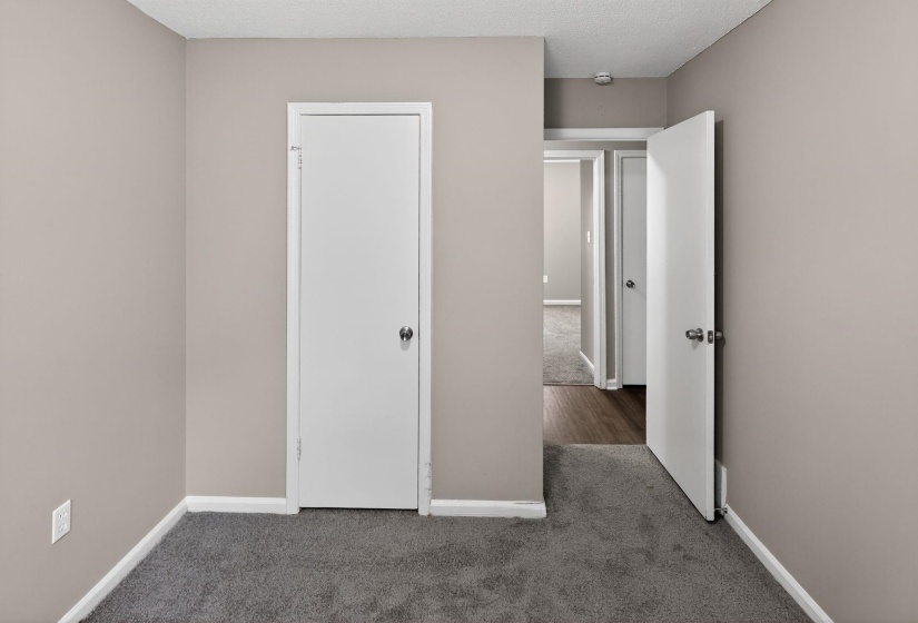 Unfurnished bedroom with carpet floors and a textured ceiling