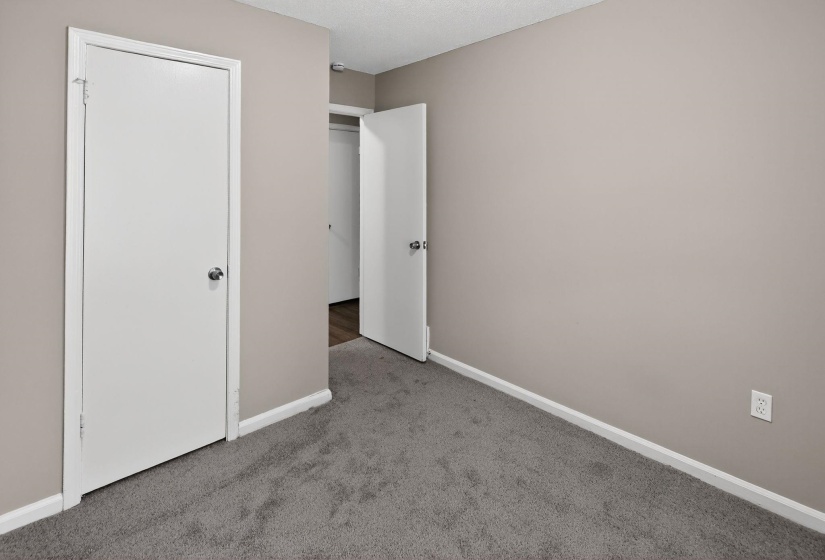 Unfurnished bedroom with light carpet and a textured ceiling