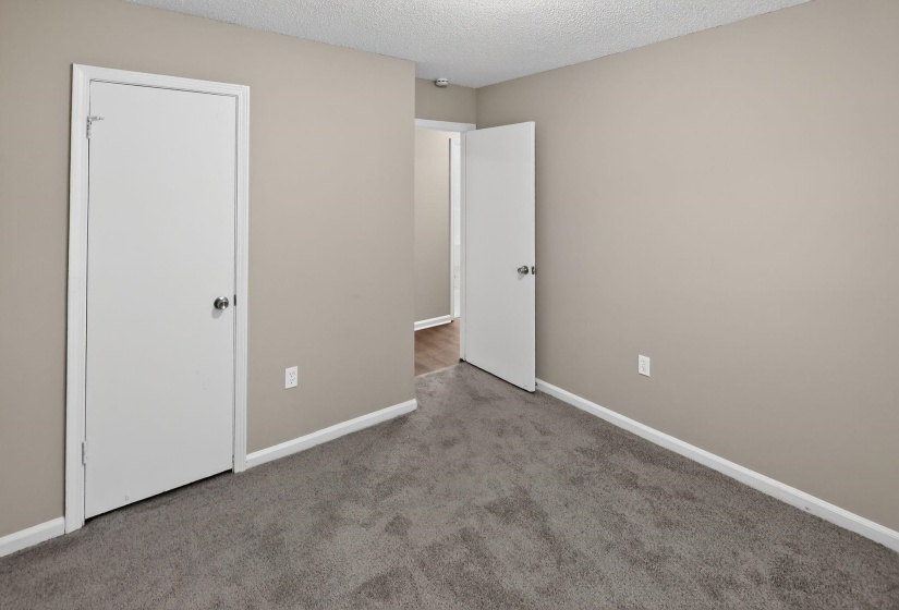 Unfurnished bedroom featuring a textured ceiling and carpet flooring