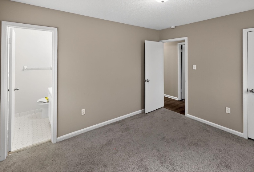 Unfurnished bedroom with carpet and ensuite bathroom