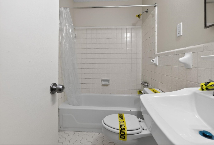Bathroom with shower / bath combination with curtain, light tile patterned floors, and tile walls