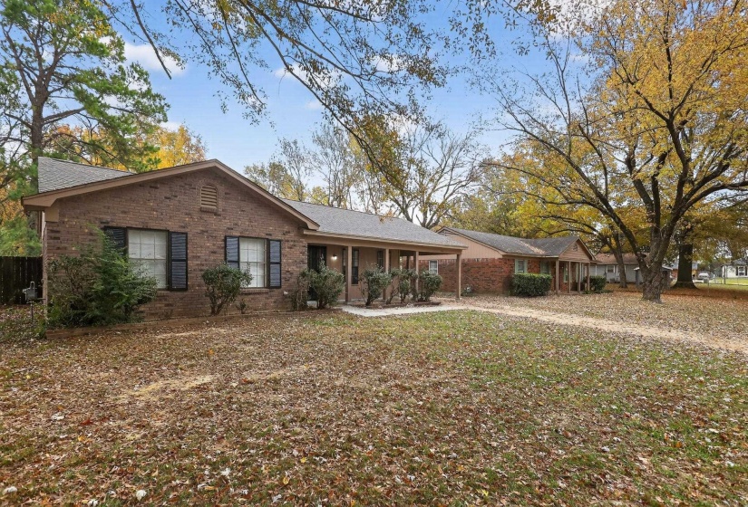 Back of house featuring brick siding and a porch